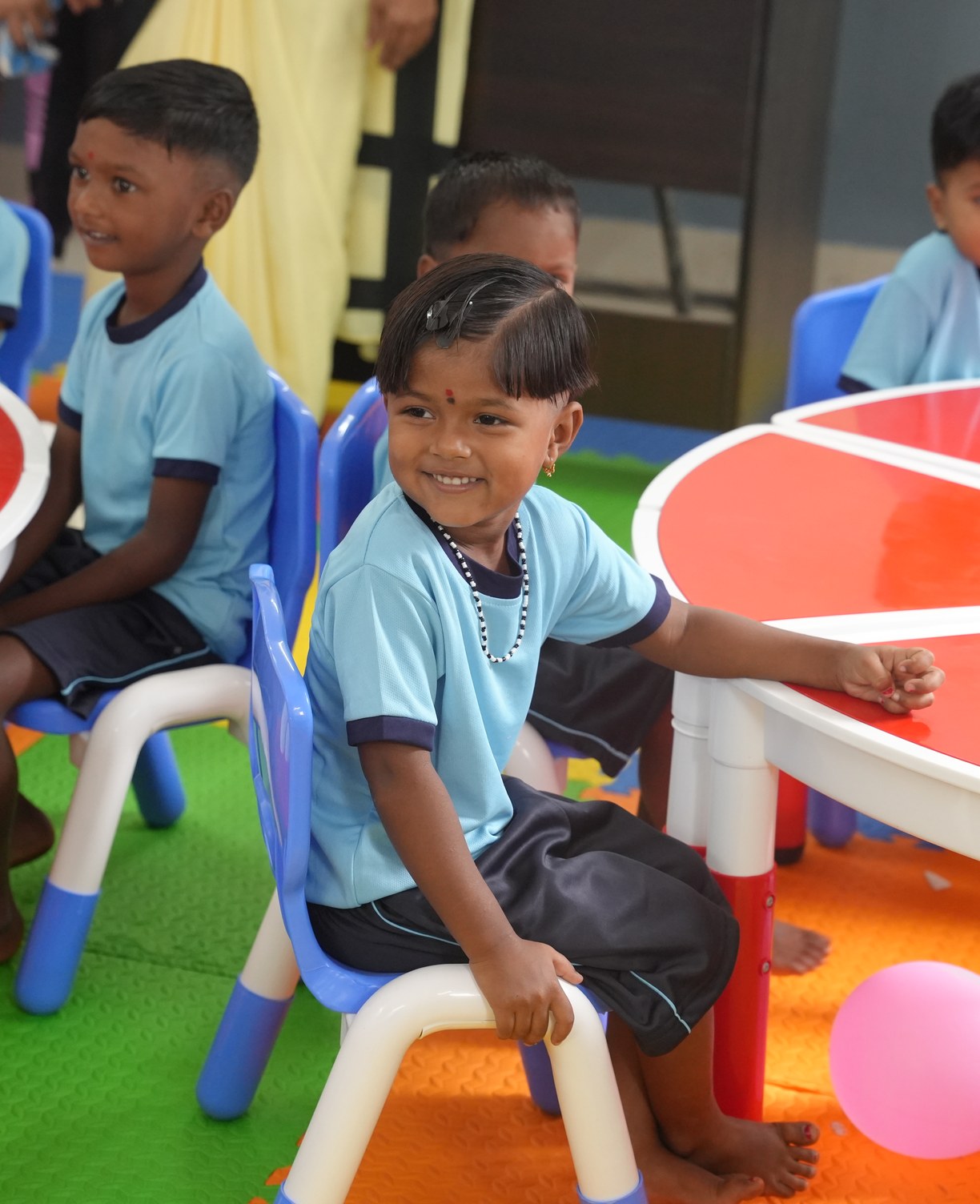 Toddlers seated at colourful tables in a transformed anganwadi