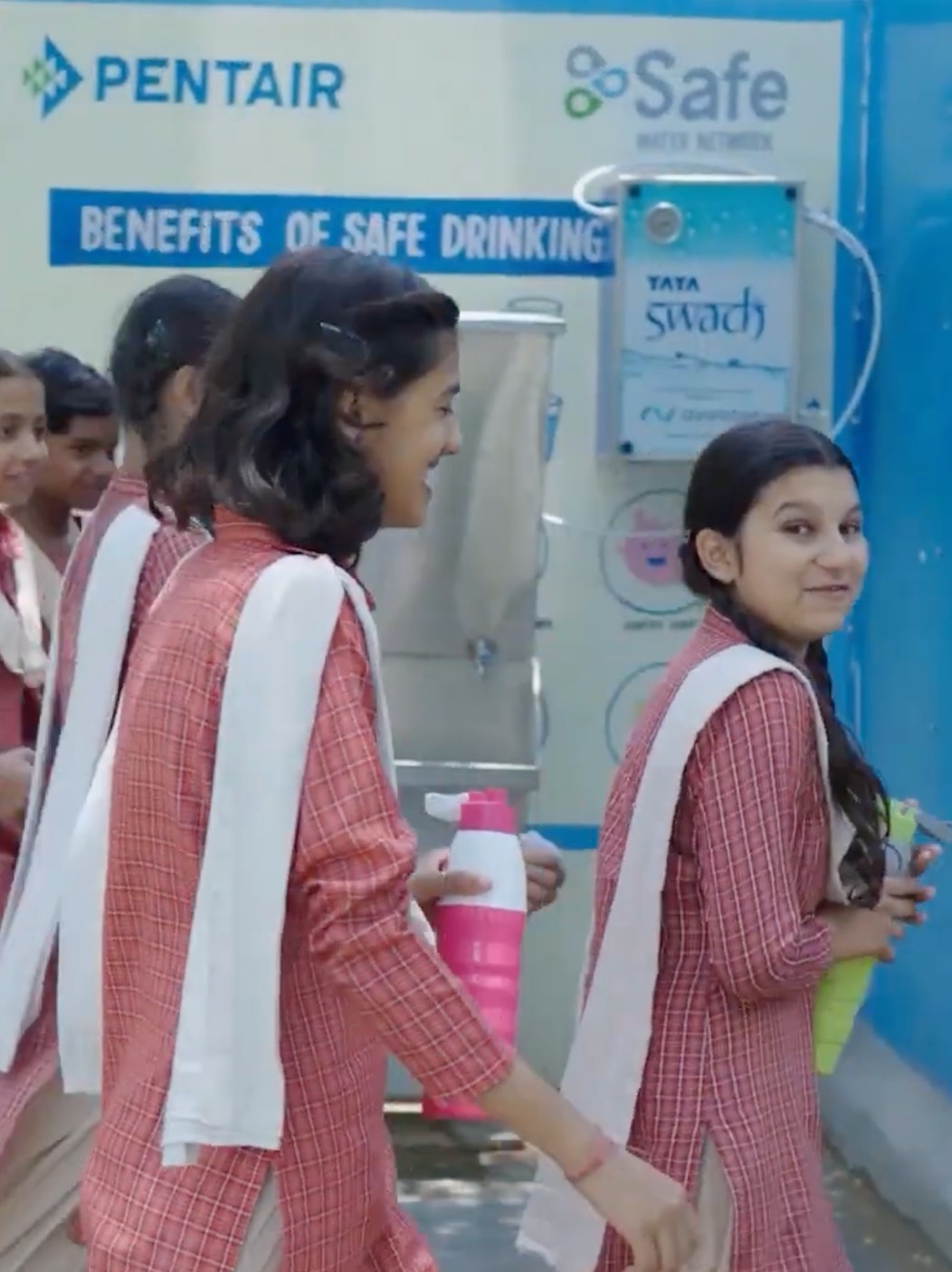 Girls filling their bottles at the school's safe drinking water unit